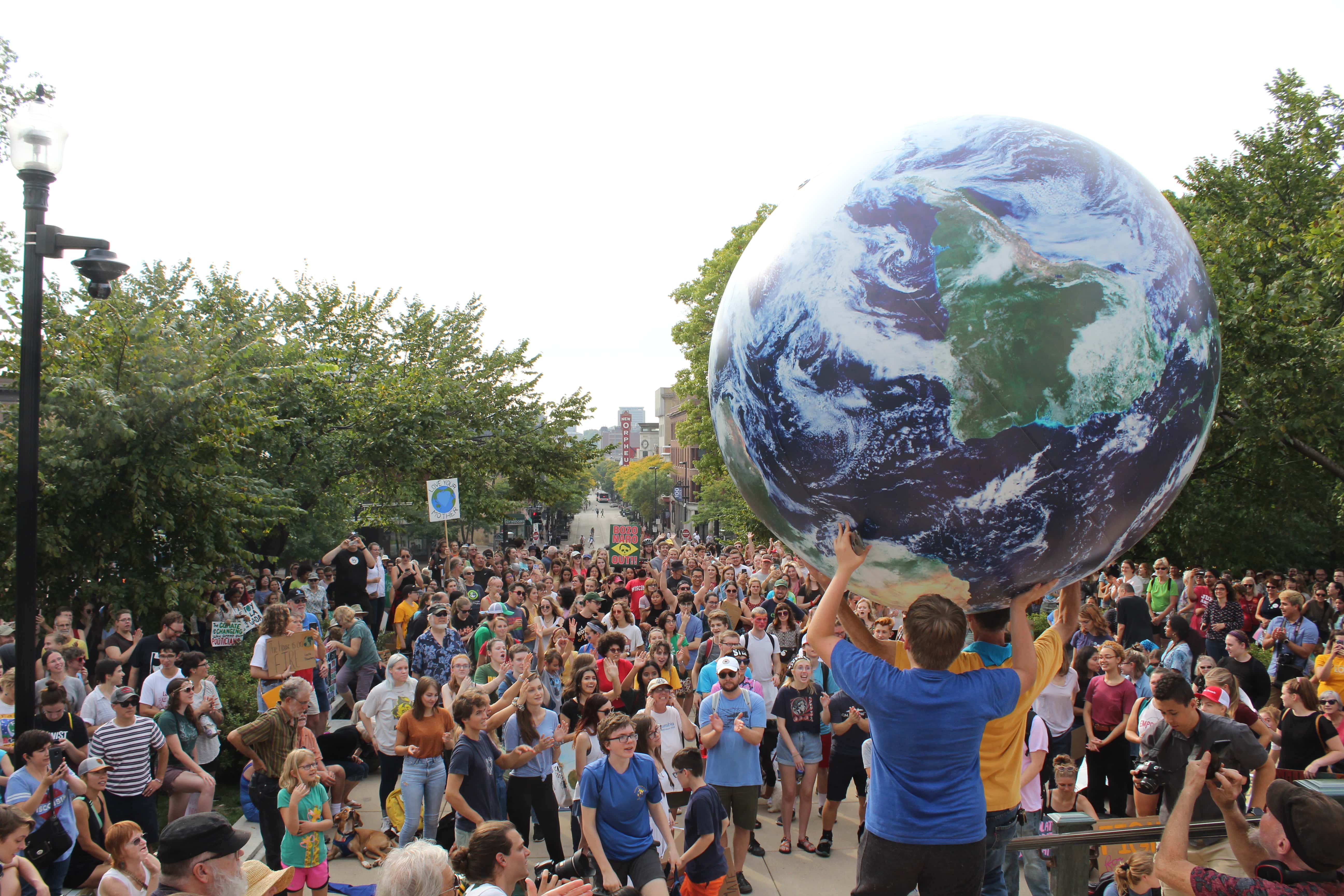 Marchers hold up an inflatable globe as thousands look on in front of the Capitol