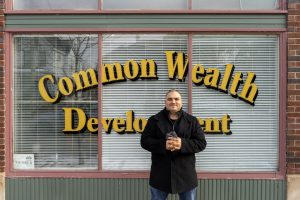 Castañeda in front of the Common Wealth Development window